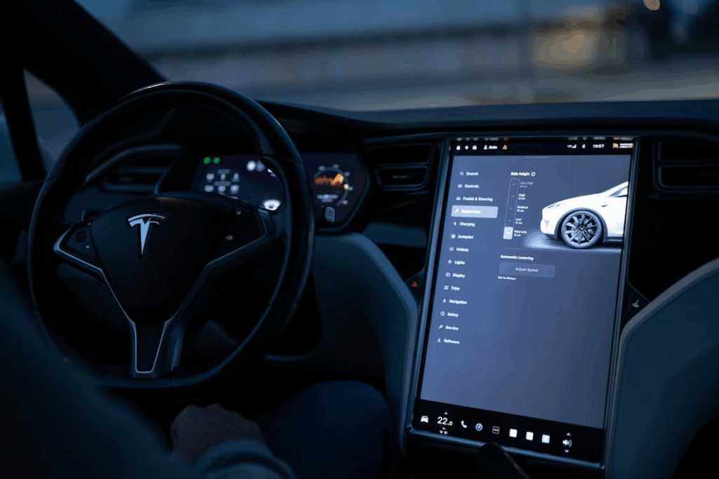 Tesla interior showcasing autonomous driving systems with digital touchscreen controls and Autopilot features on display.