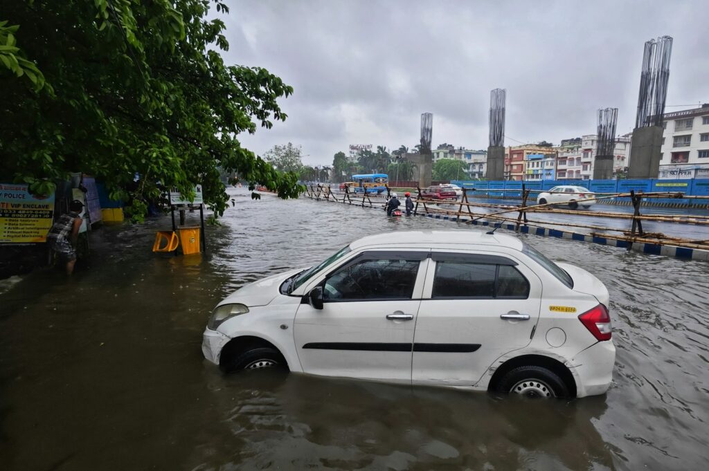 a white car driving through a flooded street